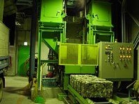 回収された鉄類・アルミ類を成型する鉄・アルミ圧縮機の写真