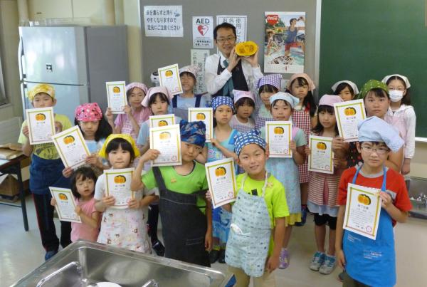 修了証書を手にした子どもたちと中橋さんの写真