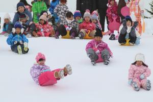 雪のすべり台ではしゃぐ子どもの写真１