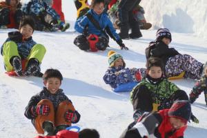 雪のすべり台ではしゃぐ子どもの写真2