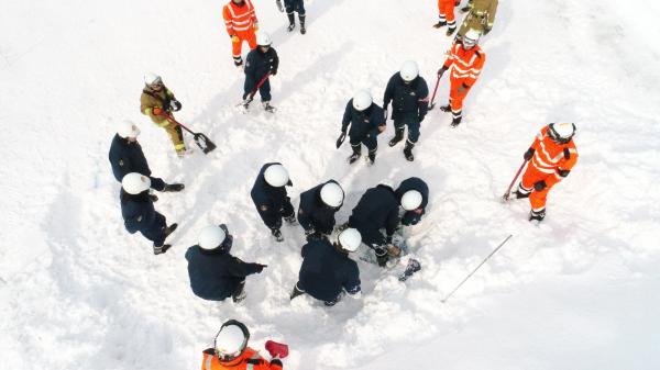 雪の中の救難者を探す訓練をする写真
