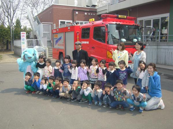 消防車の前で記念撮影する誠染保育園の園児の写真