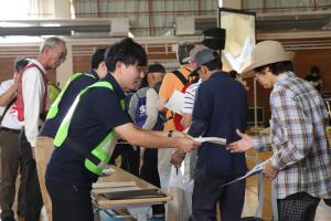 避難所で受付をする江北地区の住民の写真