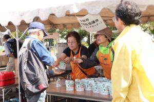 試食用の防災食を配る社会福祉協議会の職員の写真