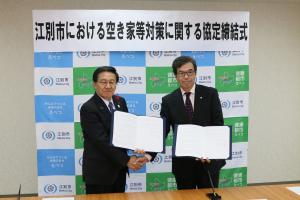 江別市長と札幌司法書士会会長が札幌司法書士会と締結した「江別市における空き家等対策に関する協定書」を持ち、
