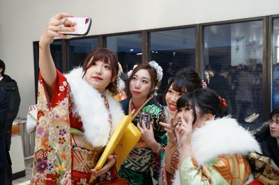 再会した友人とスマートフォンで写真を撮る新成人らの写真