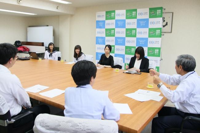 副市長に全国大会の報告をする江別高校の先生と生徒の写真