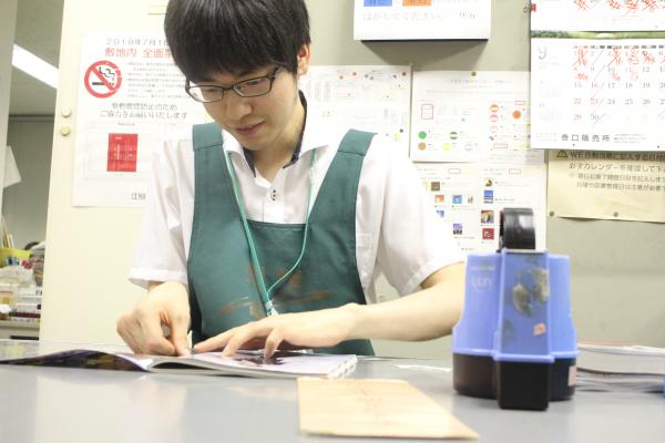 雑誌の修繕を行う江副さん