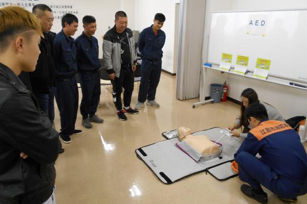 AEDの使用法の説明を受ける実習生の写真