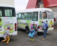 バスを降りてイチゴ狩りの前に手を消毒する幼稚園児の写真