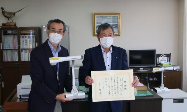 教育部長が書画カメラ、札幌東法人会江別支部　支部長が感謝状を持っている写真