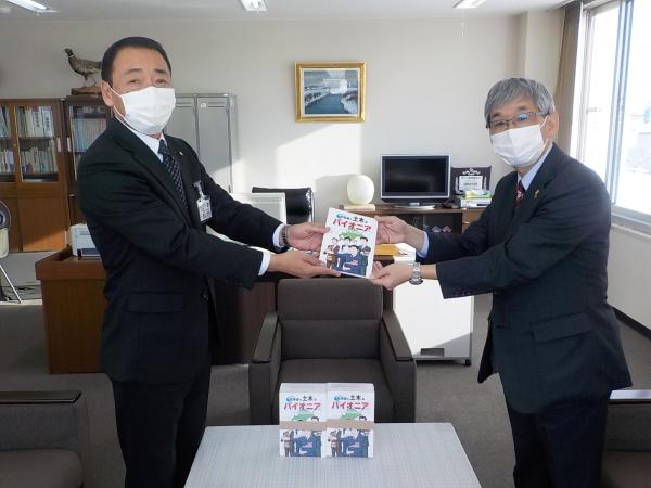 草野作工株式会社の代表取締役草野貴友氏が漫画を寄贈している写真