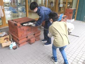 児童が窯でピザを焼く様子