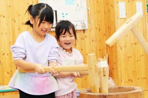 笑顔で餅をつく2人の園児