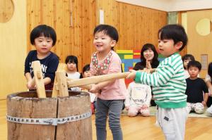 楽しそうに餅をつく3人の園児