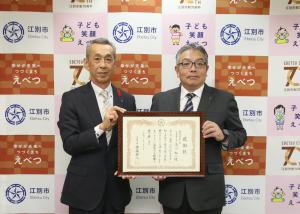 後藤市長と（株）玉川組 代表取締役 玉川裕一氏がともに感謝状を持っている写真