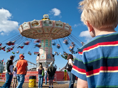 A boy watching the swings at the Puyallup Fair https://www.flickr.com/photos/bdewey/3940538919