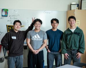 四人の若い男子生徒が立っています。